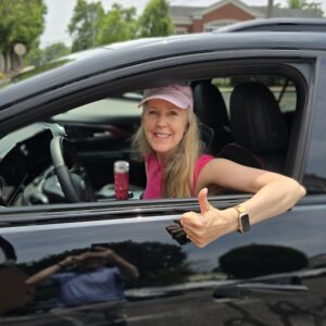 Daphne in her 2024 Chevrolet Equinox EV RS giving the thumbs up as she leaves Karl Chevrolet in New Canaan, CT